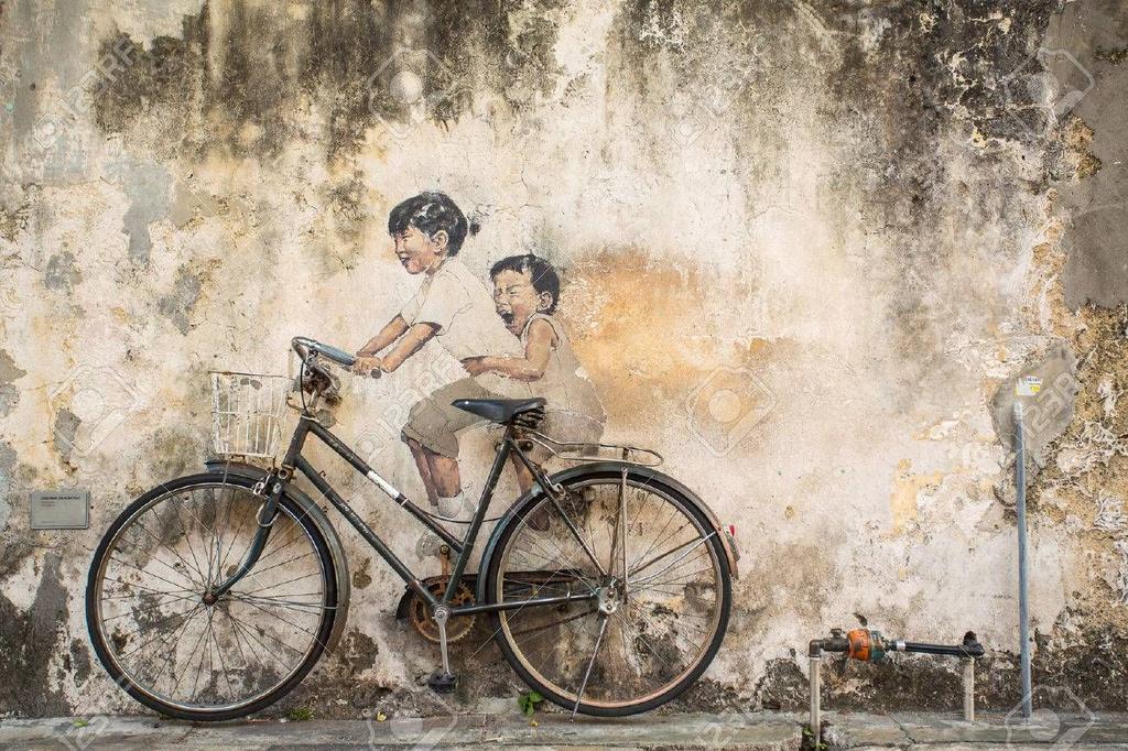 Texto 5 Na imagem, há um grafite e também uma bicicleta encostada à parede. Intervenção do artista Ernest Zacharevic, Malásia (2012). 5. No Texto 4, o narrador faz uma descrição de Isaura e de seus hábitos inusitados.