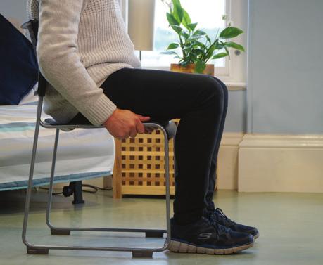 Extensão da perna (para trás) Extensão do joelho sentado Usando as costas de uma cadeira para se apoiar Mantenha-se de pé com os pés juntos
