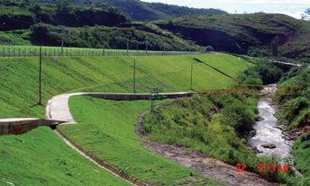 Depósito de rejeitos Galo em 2005, após a conclusão dos trabalhos de reabilitação, observando-se o talude revestido com gramíneas, drenagem de águas pluviais, caminho pedestre e uma nova ponte,