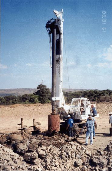 Remoção da haste, sem girar, fazendo-a girar no sentido contrário ao da perfuração, a cada 2,0 m, para auxiliar a remoção do solo aderido a haste; Apiloamento do furo com soquete de concreto