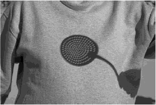 15. (Uel 2009) Com uma escumadeira de cozinha foi produzida esta curiosa imagem em uma camiseta, retratando um dos interessantes fenômenos cotidianos interpretados pela Física: a sombra.