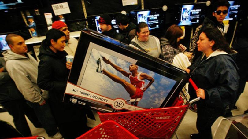 A cena da fotografia mostra pessoas numa seção de aparelhos elétricos de uma loja.