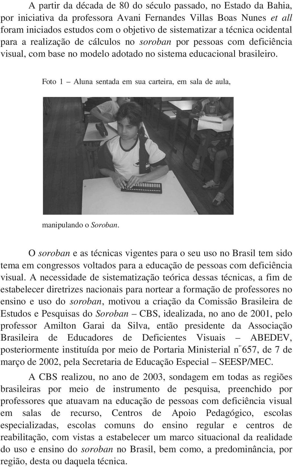 Foto 1 Aluna sentada em sua carteira, em sala de aula, manipulando o Soroban.