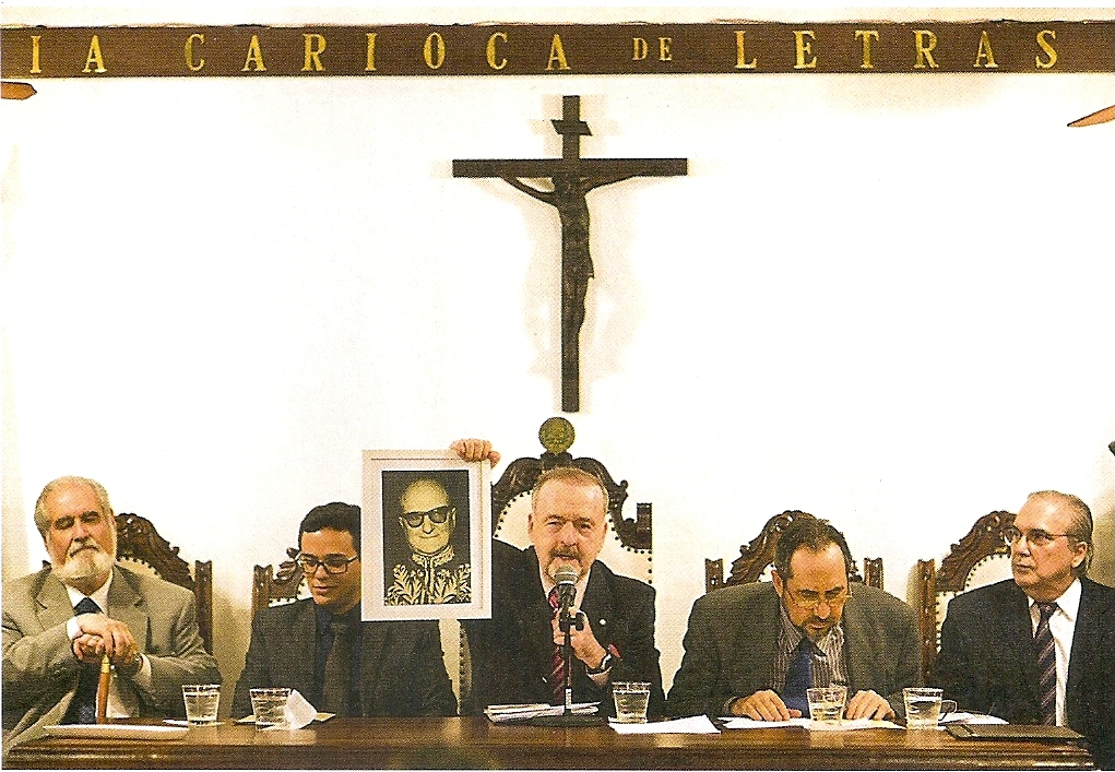 Ao centro da mesa, o presidente da ACL, o pesquisador e crítico musical Ricardo Cravo Albin, mostra um retrato de Álvaro Moreyra, antes de anunciar a presença de Martinho Martinho começou a escrever