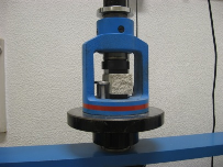 Fig. III-38 Acessório utilizado no ensaio de compressão. Fig. III-39 Ensaio de compressão de um prisma.