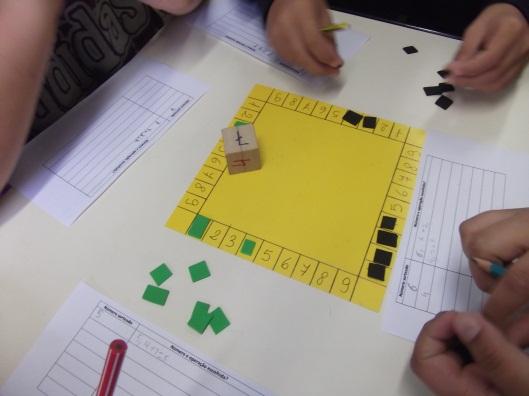 Figura 1: Cartela do Jogo e dado Fonte: Arquivo da autora, 2013 Demonstração de uma jogada possível em um grupo, conforme as figuras 7, 8 e 9: Figura 2: Exemplo de Jogada, (4 + 1) ou (2 + 3) Fonte: