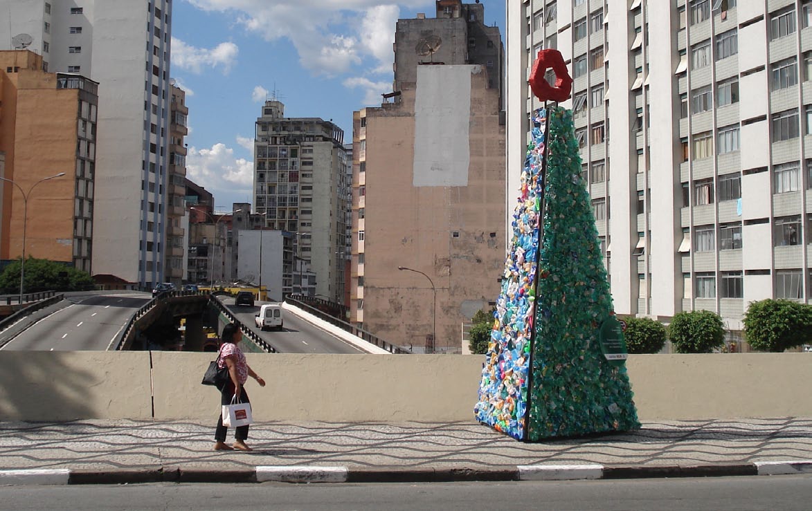 Árvores com materiais recicláveis iluminadas com energia solar.