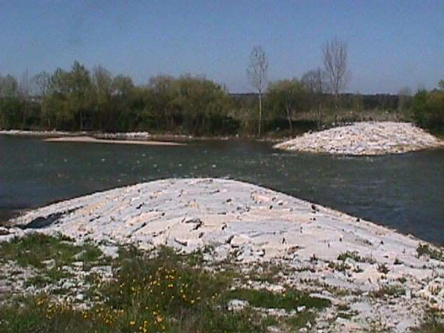 também a destruição de vários esporões (Figura 8), originado o arrastamento dos materiais que constituíam o enrocamento daquelas estruturas para o leito do rio.