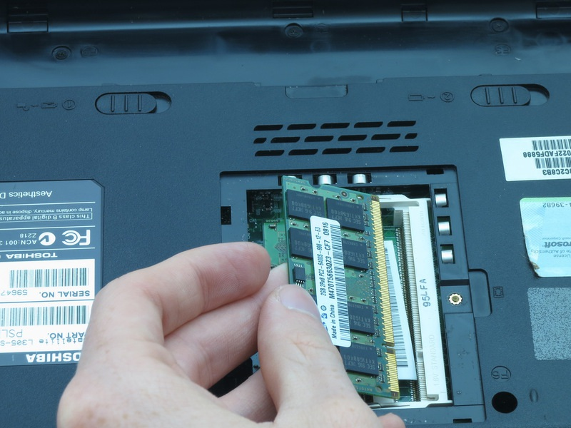Passo 9 Use suas unhas para empurrar os clipes de brancos e de prata de retenção de distância de cada lado do cartão de memória RAM. O cartão de memória RAM deve aparecer em um ângulo.