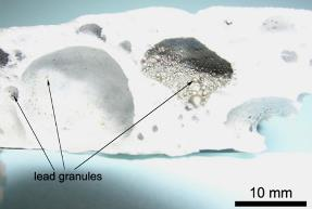 estrutura do vidro. A Figura 10 apresenta uma fotografia das partículas de chumbo dentro da estrutura do vidro. Também é possivel notar que o material final está na forma de uma espuma de vidro.