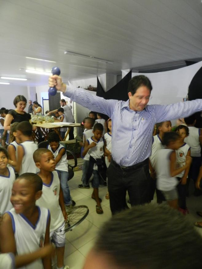 No flagrante, a criançada e a Reitora se divertem com a alegria do Pró-Reitor na plataforma giratória.