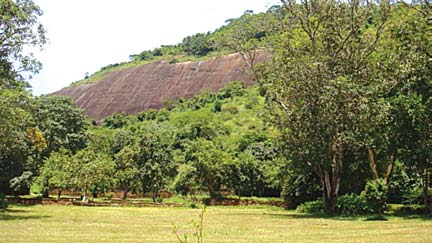 O portão fica à esquerda, defronte a uma antiga construção que lembra um armazém (f02).