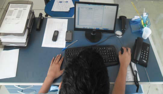 antebraços na quina da mesa e reflexo de luz da parede de vidro sobrecaregando estruturas mioarticulares da região cervical causando dor e fadiga visual.