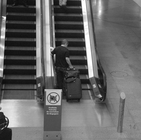 É comum ver pessoas subindo escadas rolantes com bagagem. A sinalização é falha.