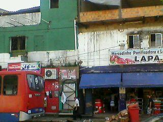 Imagem 3: FARMÁCIA DO TRABALHADOR MERCADINHO LAPA Av. Vale do Tororó, Salvador, 3 de julho de 2013. Foto: Arthur Vargens. a) Que objeto voce vê em frente à entrada do Mercadinho Lapa?