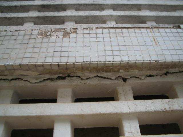 Na fachada nordeste, que consiste numa típica empena cega sem qualquer tipo de abertura, revestida no todo em cerâmica cinza clara, permitiu-se observar danos essencialmente nas paredes contínuas