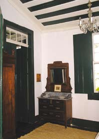 O beiral apresenta uma bela cimalha em madeira com friso decorativo em verde.