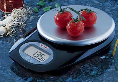 Pesando tomates Questões que podem ser colocadas a partir desta imagem: 2 O que pesa mais: os três tomates ou uma embalagem de manteiga? Como escreves o peso assinalado na balança em kilos?