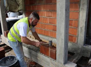 Começa com a colocação uma camada de argamassa sobre a viga inferior ao longo da linha da construção de parede (ver