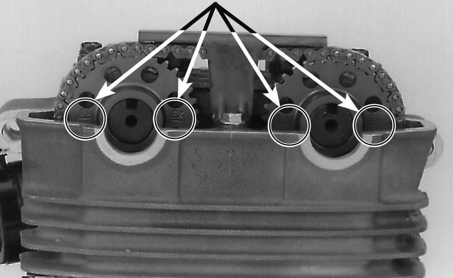 CABEÇOTE/VÁLVULAS XR250 Gire lentamente a árvore de manivelas no sentido antihorário, segurando a corrente de comando, a fim de alinhar a marca T do volante do motor com o entalhe de