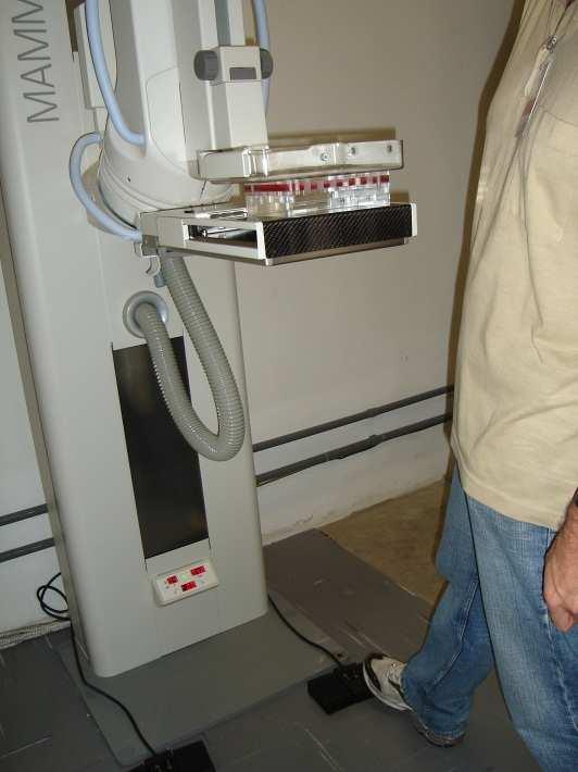 iv. Abaixar a bandeja de compressão até que ela toque a superfície do simulador (figura 19); Figura 19: Posicionamento da bandeja de compressão v.