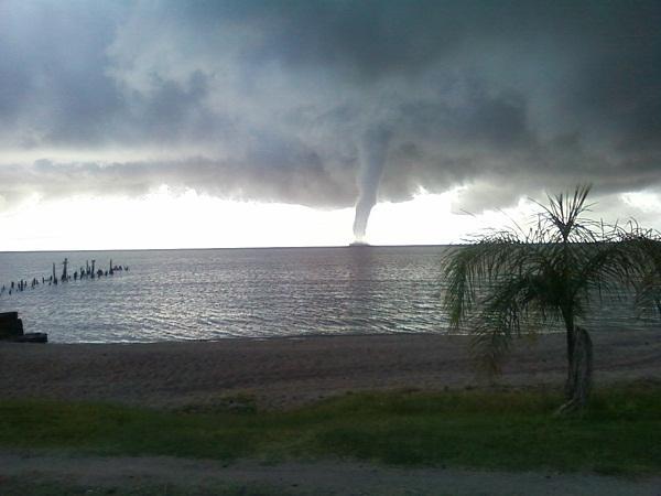 (c) (d) Foto 1: Eventos extremos no RS e em SC: (a) granizo em Caxias do sul-rs, (c) temporal em Água Doce-SC, (c) Tromba d água em Arambaré-RS e (d) tornado em Capivari-RS.