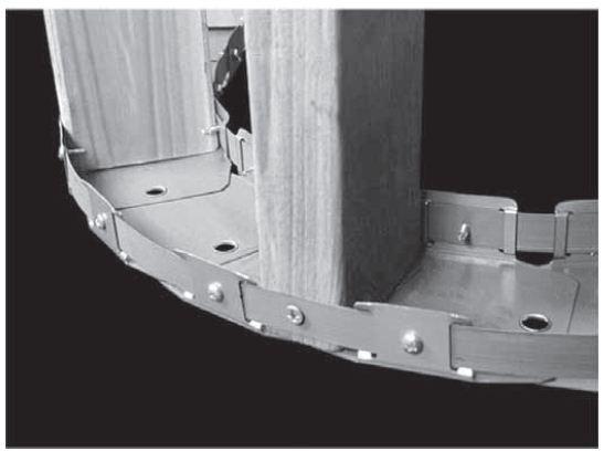 Para manter o raio da curvatura e reforçar a guia, uma fita de aço galvanizado deve ser fixada na face externa da mesa da guia, através