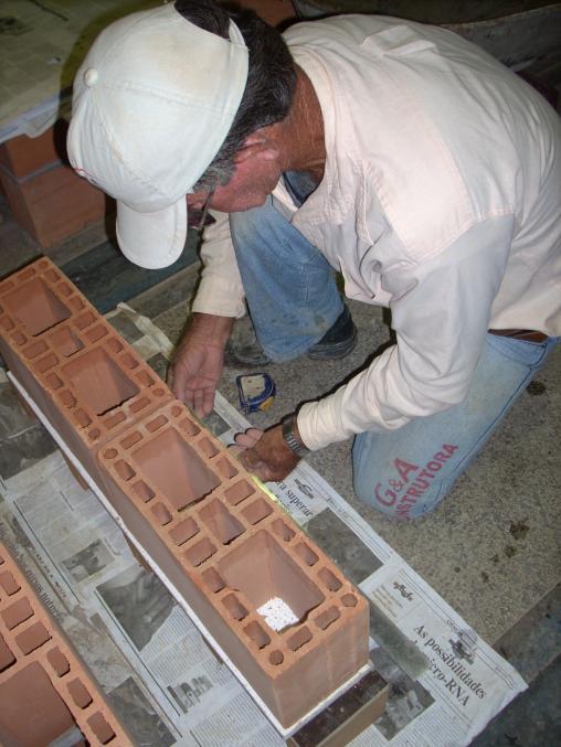 A construção da pequena parede iniciou-se com a verificação do nivelamento do suporte de madeira e do
