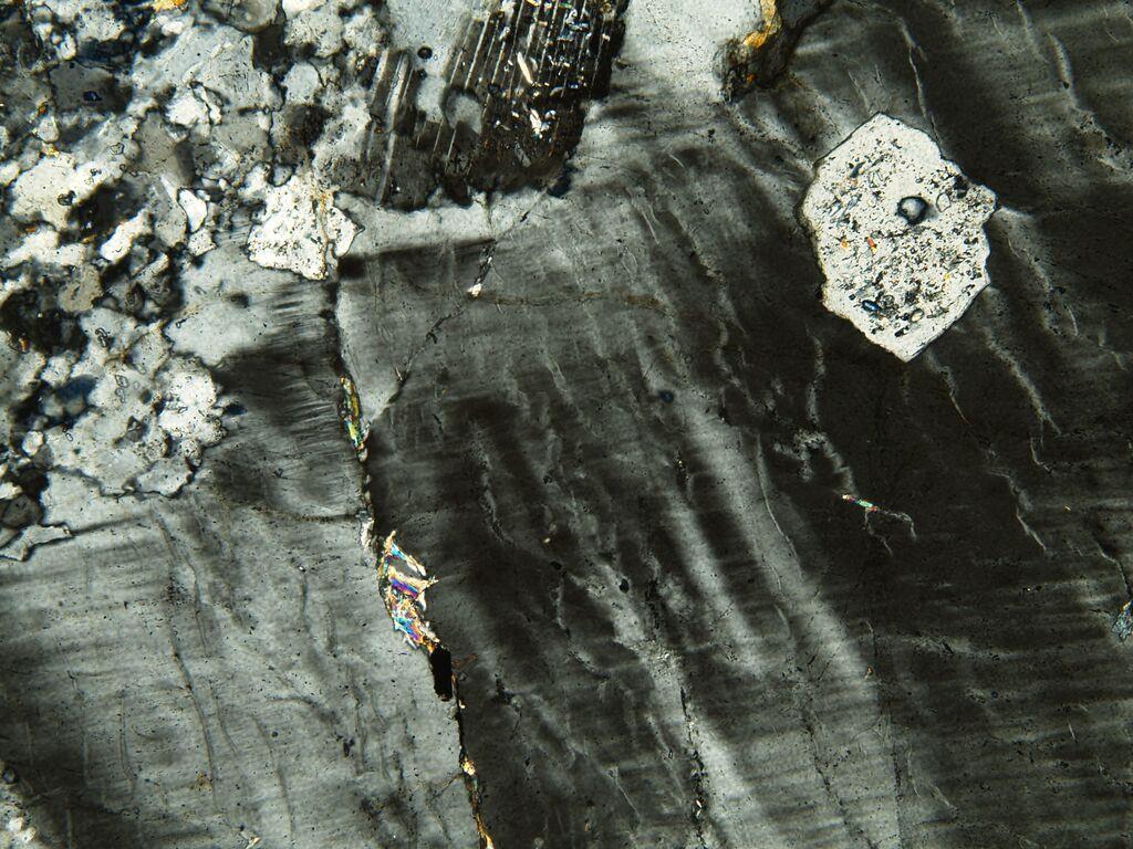 16 Rocha ígnea de composição granítica, talvez na fáceis Alfibolito que sofreu metamorfismo com deformação e formação inclusive de uma xistosidade dada pela orientação do feldspato.