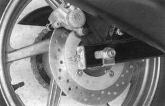 CB500 SISTEMA DE FREIO Instale a roda traseira e verifique se o disco de freio traseiro está encaixando apropriadamente entre as pastilhas.