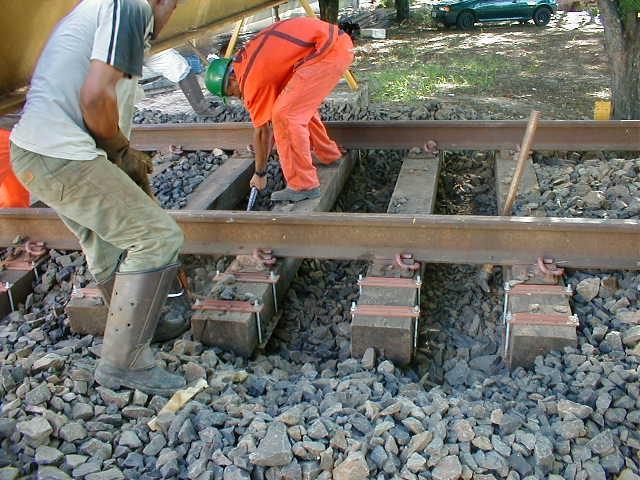 As placas de aço são compostas por duas chapas de aço com 200 x 200 x 6,3 mm (largura, altura e espessura, respectivamente), soldadas em ângulo de 90 o e fixadas na base dos dormentes abaixo dos