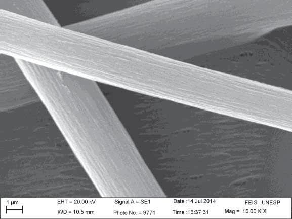 54 Figura 25- Micrografias da manta obtida pela técnica de FSS, contendo a concentração em massa de 30,0 % de PVDF, mantendo fixos os demais parâmetros. Ampliações: (a) 15000 vezes e (b) 3000 vezes.