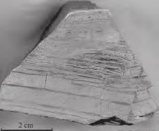 The metamorphosed Penge Iron Formation is very fine grained with alternating dark iron oxide bands and light gray laminae containing chert, grunerite, and ankerite, with the following main assemblage