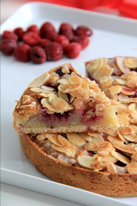 Torta AMÊNDOAS E FRAMBOESAS Delicada massa doce com recheio a base de amêndoas, framboesas e limão, coberta com lascas