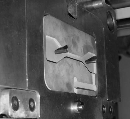 Figura 3: Insertos usinados em placa de epóxi e aço, respectivamente A máquina injetora utilizada foi uma ARBURG 320S 500-150 3 com rosca de 35 mm de diâmetro, cujos parâmetros de injeção adotados