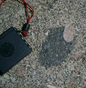 Em superfícies mais recentes, a rocha apresenta uma coloração rosada devido à presença do feldspato potássico (Figura 6B).