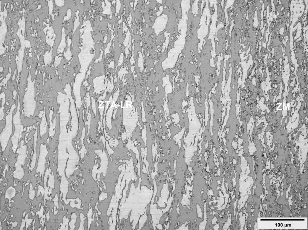 Figura 5 - Micrografia obtida por microscopia óptica na região de transição entre a zona misturada (ZM) (à direita) e zona termicamente afetada, no lado