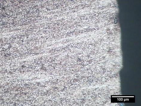 A micrografia da superfície transversal da fratura mostra que a microestrutura, martensítica, sofreu deformação, comprovando a fratura dúctil.