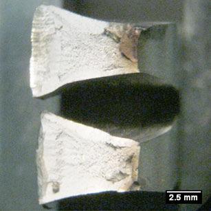 109 A Ilustração 95 apresenta a fratura do corpo de prova 2 do aço SAE 4140 temperado em óleo e revenido a 140ºC. A superfície de fratura é caracterizada dúctil, com aspecto cinzento.