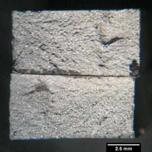 A micrografia da superfície transversal da fratura mostra que a microestrutura, martensítica com ilhas de perlita fina e ferrita, sofreu pouca deformação, comprovando a fratura