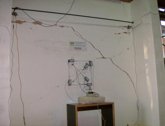 metálicos ancorados à laje do laboratório. A aplicação da força à parede durante o ensaio efectuou-se através de um actuador hidráulico, com capacidade de impulsionar uma carga máxima de 90kN.