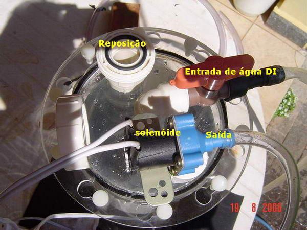 A água entra pelo registro marrom e é direcionada para o fundo do reator, agitando o hidróxido de cálcio decantado e empurrando para fora do reator a solução