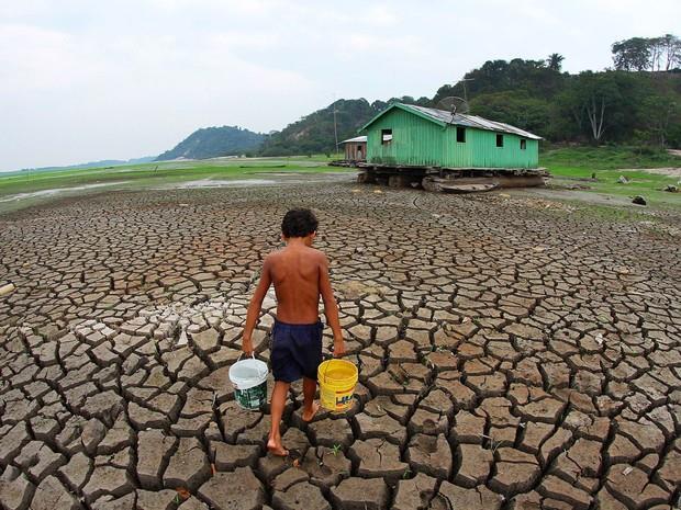 Foto 01 - Criança carrega água para beber no Lago