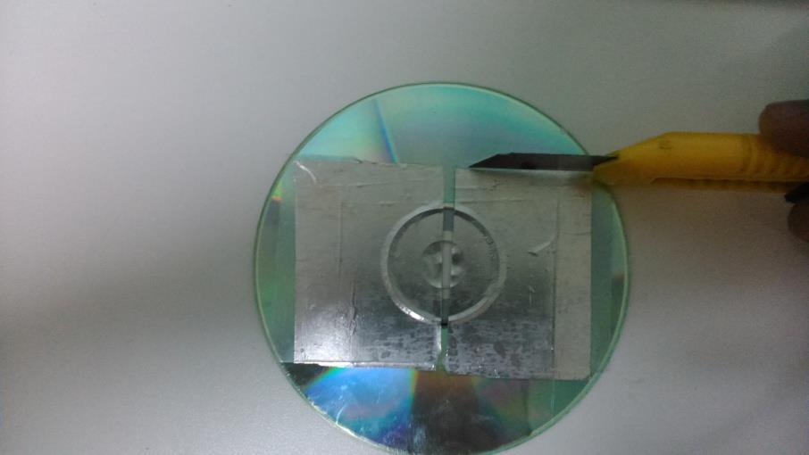 Figura 8 - Tiras de papel alumínio coladas no CD Cole duas tiras de fita dupla face no outro CD de modo que seja possível colar a outra tira de papel alumínio conforme a Figura 9.