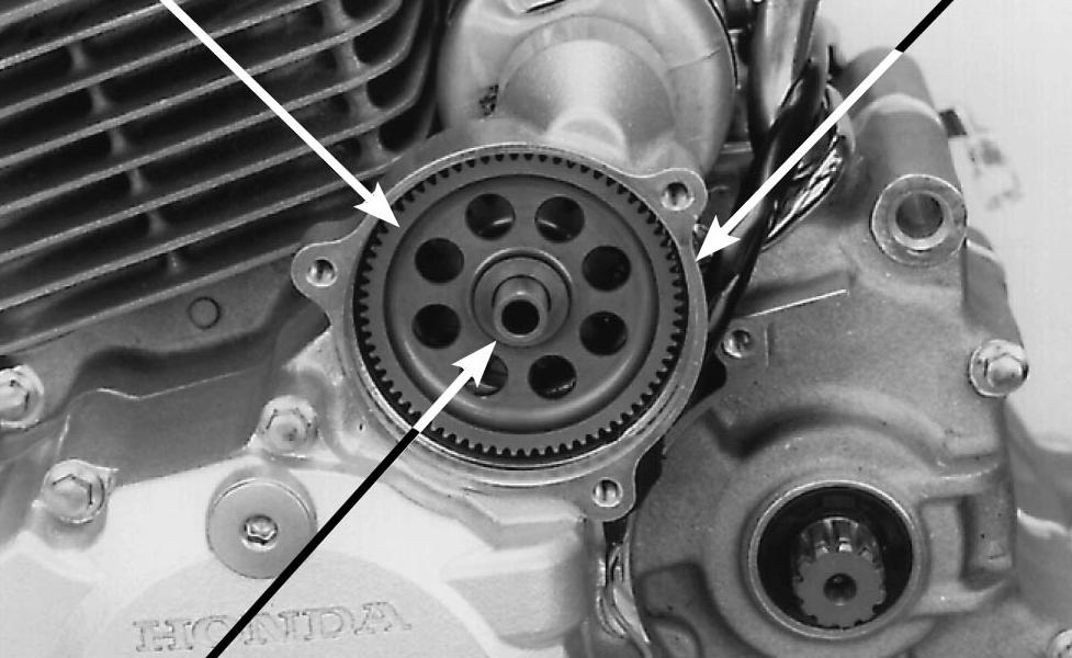 Remova a engrenagem intermediária de partida e seu eixo da tampa lateral esquerda da carcaça do motor. EIXO Remova a tampa lateral (página 2-2).