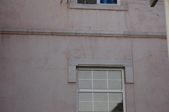 Fissuras com orientação irregular, junto dos tubos de queda, na fachada