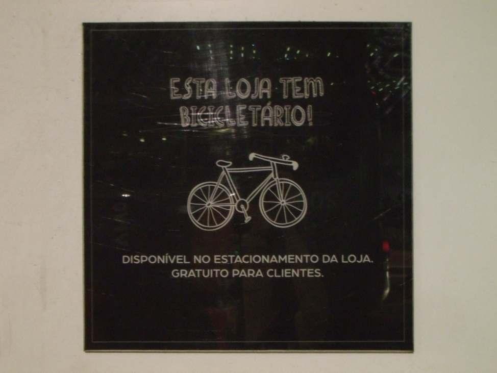 3 Foto 2: Placa anunciando bicicletário para clientes de uma loja de varejo na região central da cidade.