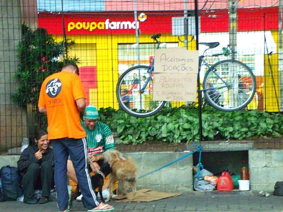 5 Foto 6: Grupo de moradores de rua expõe bicicleta com o anúncio Aceitamos Doações, próximo ao