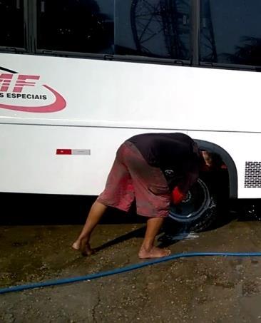 Para lavar as rodas do carro, colaborador flexiona