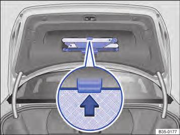 Triângulo de segurança Fig. 21 Na tampa do compartimento de bagagem: suporte para o triângulo de segurança. Com a tampa do compartimento de bagagem aberta, pressionar o suporte (lupa) Fig.